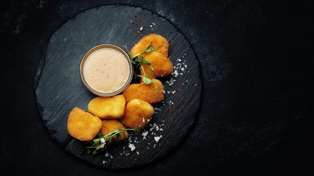 Nuggets de queijo com molho em pedra preta