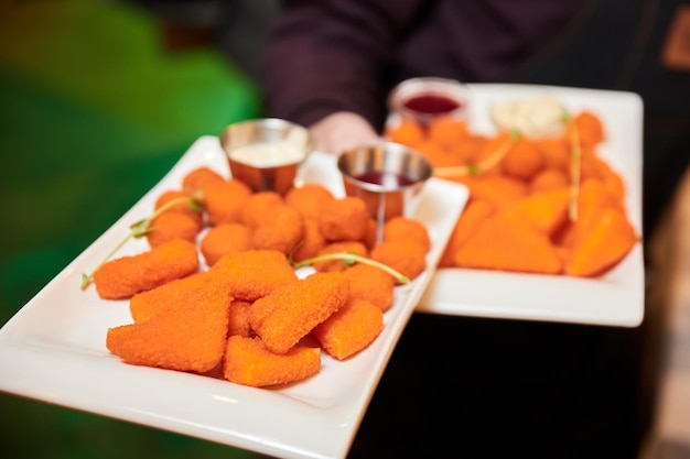 Nuggets de queijo com molho num prato branco