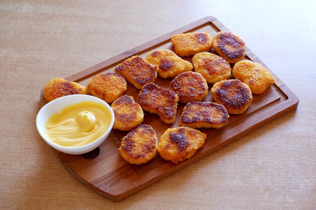 Nuggets fritos e molho de queijo na mesa