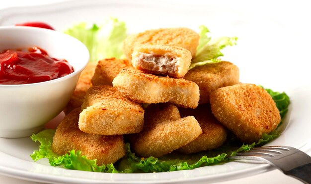 Nuggets de pechuga de pollo frito en hojas de lechuga con salsa de tomate horizontal nadie selectivo