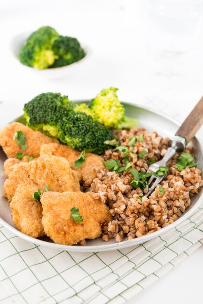 Nuggets de pollo caseros con trigo sarraceno y verduras en un plato