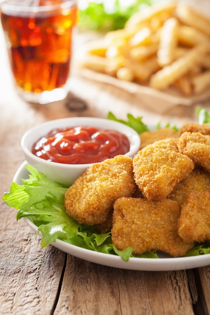 Nuggets de pollo de comida rápida con salsa de tomate, papas fritas, cola