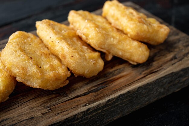 Foto nuggets de pollo crujientes fritos sobre fondo de madera oscura