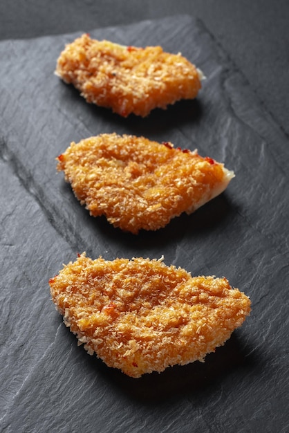 Nuggets de pollo crujientes fritos sobre un fondo negro