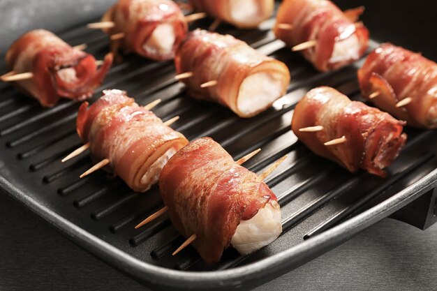 Nuggets de pollo envueltos en tocino en la parrilla closeup