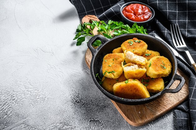 Nuggets de pollo frito crujiente en una sartén