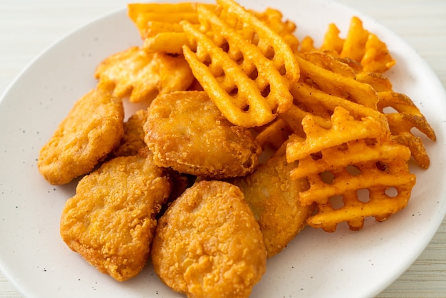 Nuggets de pollo frito con patatas fritas en la placa