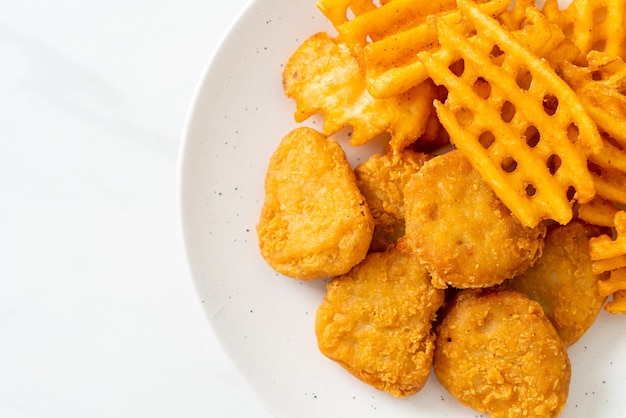 Nuggets de pollo frito con patatas fritas en la placa