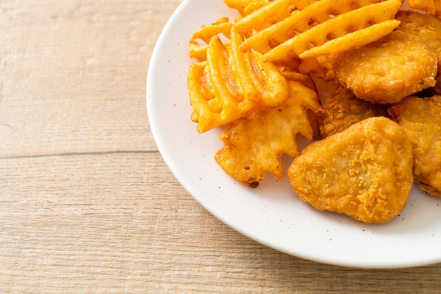 Nuggets de pollo frito con patatas fritas en la placa