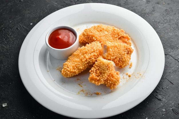 Nuggets de pollo frito con salsa de ketchup en un plato Vista superior