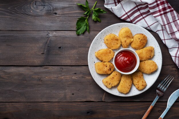 Nuggets de pollo frito con salsa de salsa de tomate. mesa de madera. Copia espacio