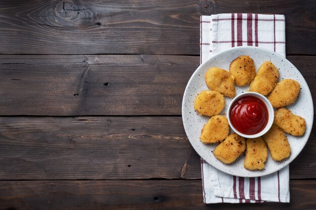 Nuggets de pollo frito con salsa de salsa de tomate. mesa de madera. Copia espacio