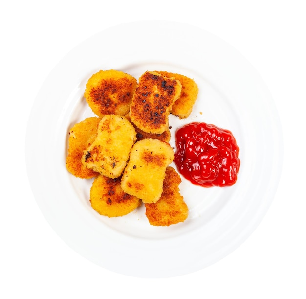 Nuggets de pollo con ketchup en plato aislado