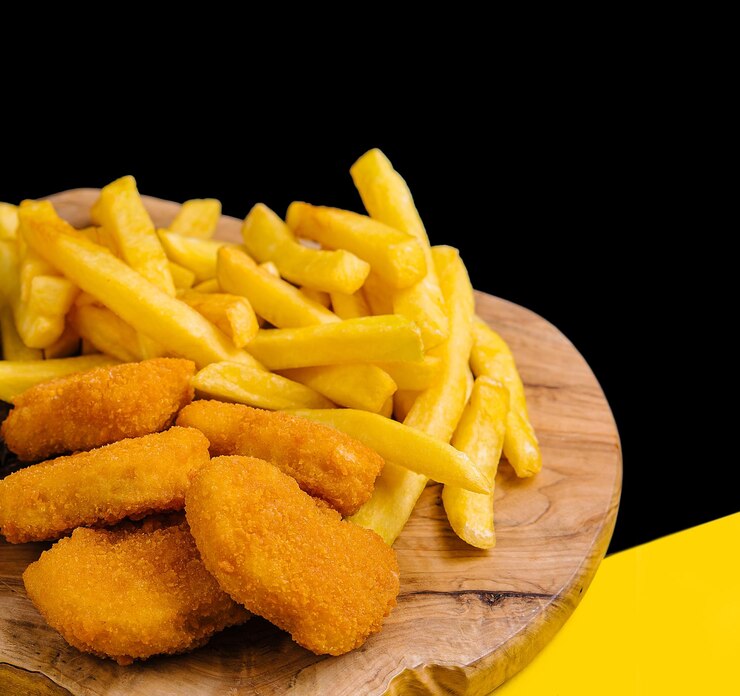 Nuggets de pollo y papas fritas en tablero de madera