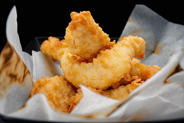 Nuggets de pollo en papel sobre un fondo oscuro