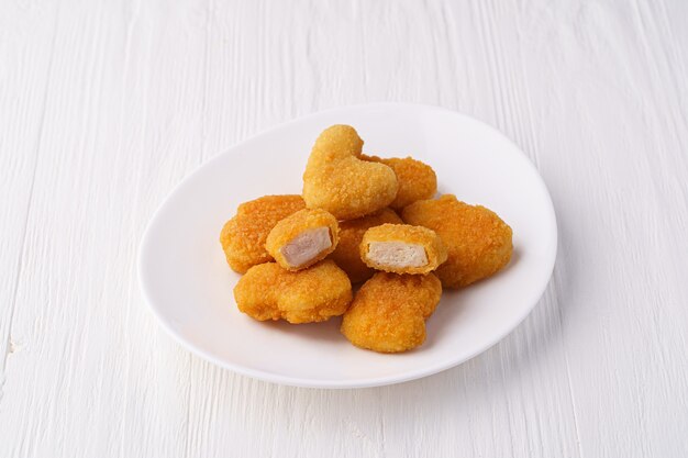 Nuggets de pollo en una placa blanca.