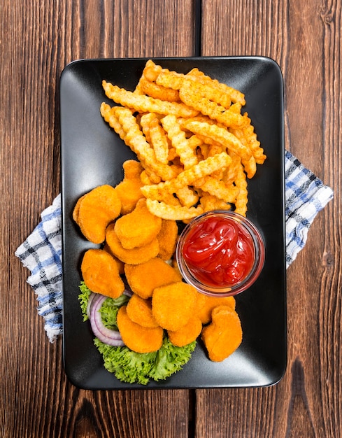 Foto nuggets de pollo recién hechos con patatas fritas