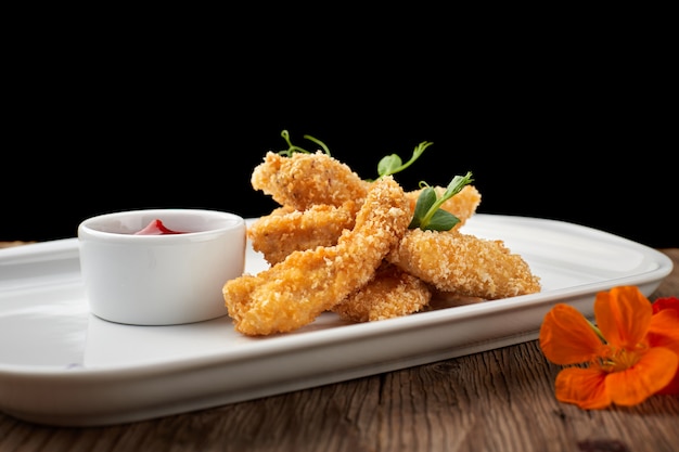 Nuggets de queso con salsa en un plato blanco