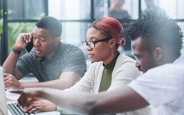 Num escritório moderno, uma equipa diversificada de gestores numa reunião de empresa para discutir projetos empresariais