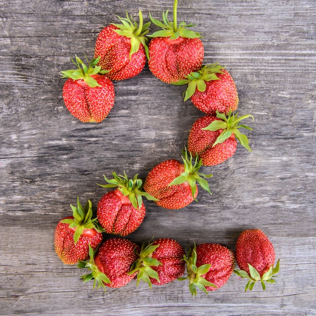 Número 2 de fresas sobre fondo de madera