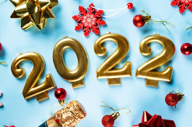 Número 2022 con botella de cava y decoración. Feliz año nuevo y concepto festivo. Vista horizontal superior, copyspace. Año nuevo rotundamente. Flatlay navideño. Año nuevo 2022. Concepto de año nuevo.