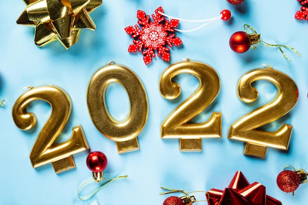 Número 2022 con botella de cava y decoración. Feliz año nuevo y concepto festivo. Vista horizontal superior, copyspace. Año nuevo rotundamente. Flatlay navideño. Año nuevo 2022. Concepto de año nuevo.