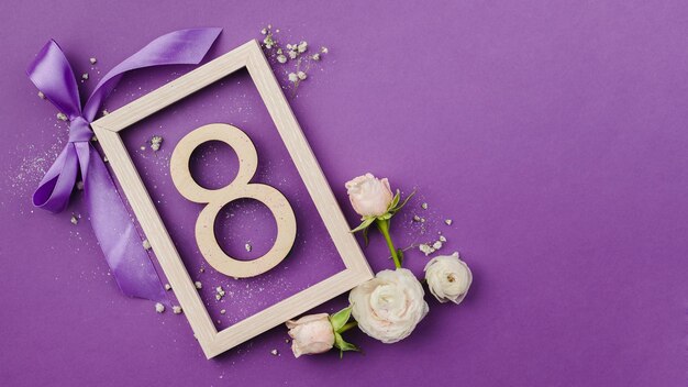 número 8 con flores púrpuras y un regalo sobre un fondo púrpura