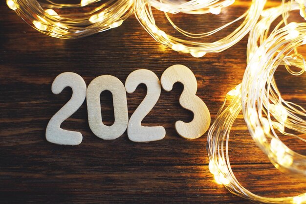 Foto número de madeira 2023 em fundo de madeira brilhante de natal com guirlanda de ouro festiva brilhante