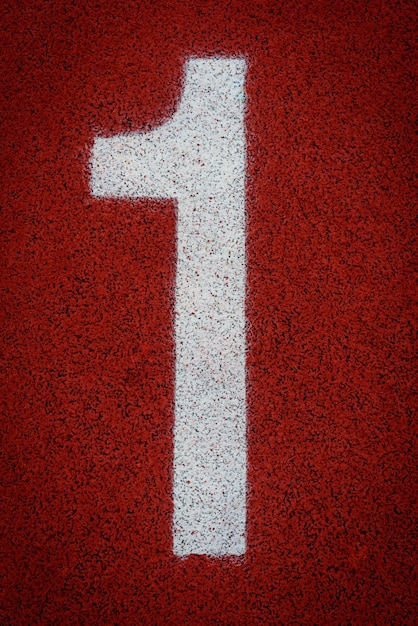 Número uno en el inicio de una pista de atletismo en el estadio