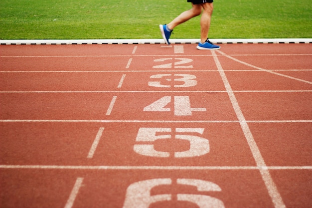 Número de pista de atletismo y gente de atletismo que corre ejercicio en el campo de pista al aire libre