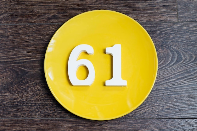 El número sesenta y uno en la placa amarilla.