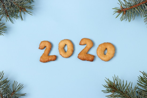 Números 2020 Feliz Navidad de la vista superior de galletas de jengibre, fondo azul