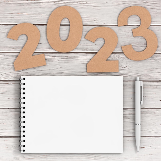 Números de cartolina 2023 Sinal de Feliz Ano Novo perto de Caderno de Capa de Papel Espiral Branca com Caneta sobre a mesa Renderização 3d