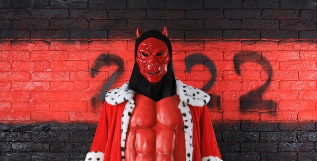 Números negros del diablo 2022 en una pared de ladrillo rojo