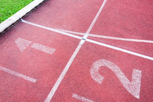 Números ponto de partida na pista de corrida vermelha e grama verde Atletismo direto Pista de corrida no Sport Stadium