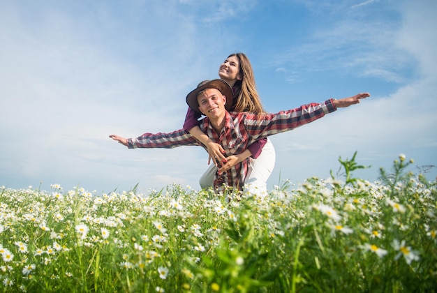 Nunca chato férias de verão em família feliz homem e mulher apaixonada desfrutam de clima de primavera relações felizes garota e cara no campo casal romântico com flores de camomila na data