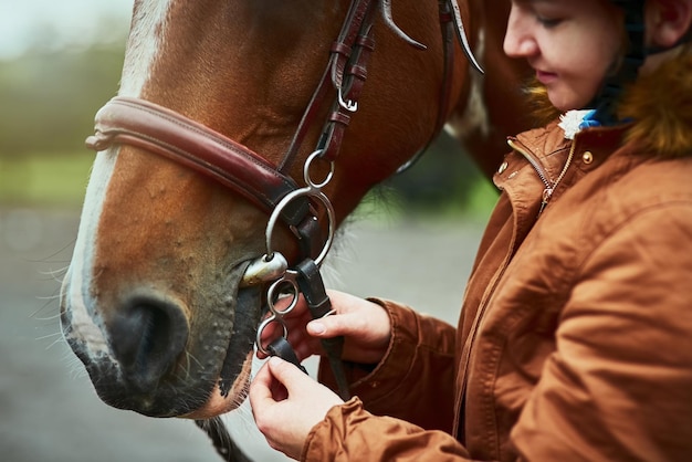 Nunca hay una buena razón para no montar Fotografía de una adolescente preparándose para montar su pony en una granja