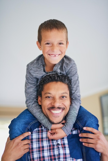 Foto nunca hay un momento aburrido cuando están juntos retrato de un padre cargando a su hijo sobre sus hombros en casa