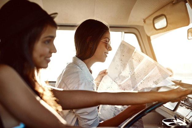 Nunca sabes a dónde te llevará la vida Foto de dos amigos leyendo un mapa en su viaje por carretera