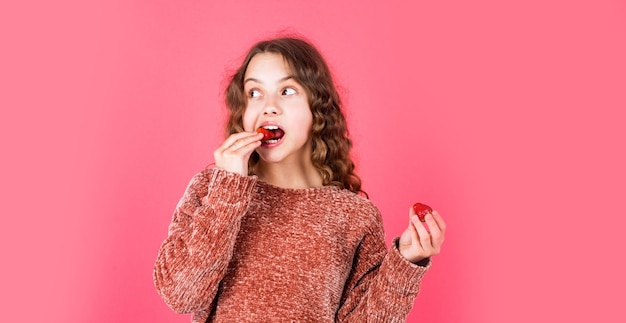 Nur gesunde Bio-Lebensmittel essen Mädchen mit Erdbeeren, die Erdbeeren zum Frühstück essen, kleines Kind, das Beeren isst, Sommerzeit, Kindheit