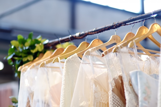 Foto nur wenige elegante hochzeits-, brautjungfern-, abend-, ballkleid- oder ballkleider auf einem kleiderbügel in einem brautgeschäft.