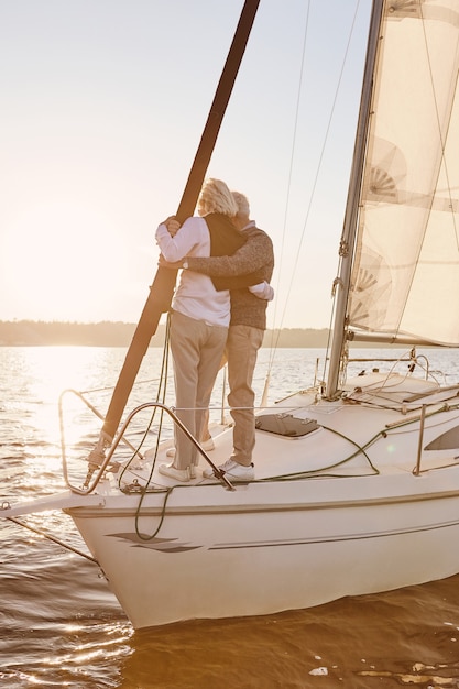 Nur wir glückliches älteres Paar, das auf der Seite des Segelboots oder des Yachtdecks steht, das im Seemann schwimmt, und
