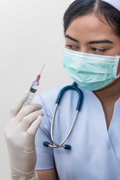 Nutra a posse da seringa médica com a agulha na ampola que prepara-se para a injeção paciente.