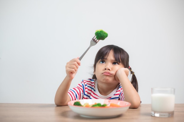 Nutrição de hábitos alimentares saudáveis para o conceito de crianças as crianças não gostam de comer legumes menina bonita se recusa a comer legumes saudáveis