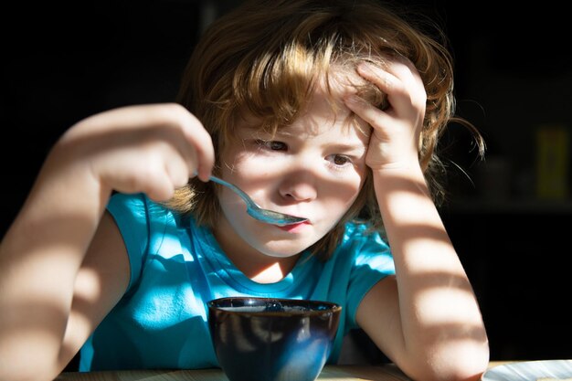 Nutrição para crianças Comida caseira Menino toma café da manhã na cozinha