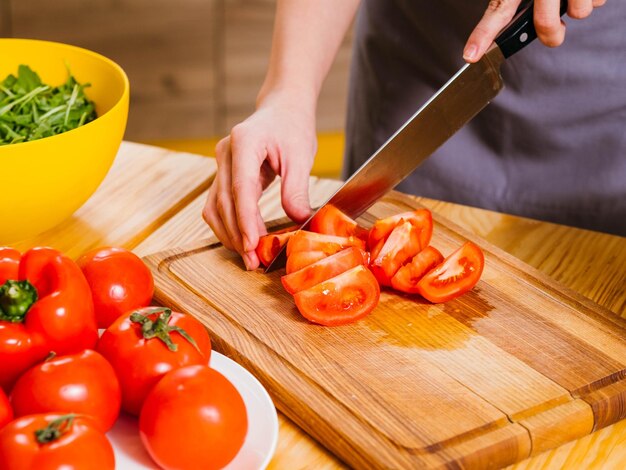 Nutrición saludable Captura recortada de mujer cocinando tomates picados para ensalada