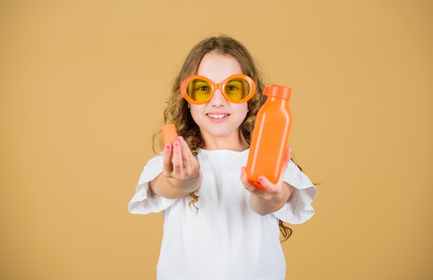 Nutrición de vitamina Gafas de sol para niños de moda beber jugo de vitamina refrescante Cuidado de la salud Dieta de vitamina de verano Infancia feliz Fuente de vitamina natural Las niñas comen verduras de zanahoria y beben jugo de zanahoria