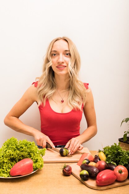 Nutricionista chica se sienta en una mesa con verduras