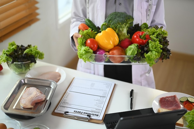 Foto nutricionista de casaco branco segurando uma tigela de vegetais para uma alimentação e dieta saudáveis