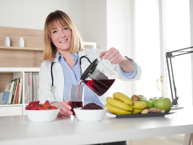 Nutricionista femenina vertiendo bebida de infusión de hibisco